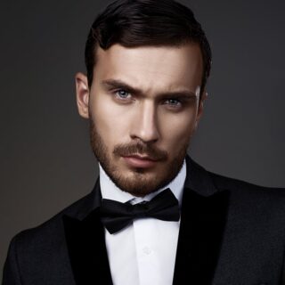 Polished & Powerful: Mastering Social Etiquette for the Modern Man 7 | The British School of Excellence | Polished & Powerful: Mastering Social Etiquette for the Modern Man A striking portrait of a man in formal attire, featuring a tuxedo and bow tie, showcasing confidence and style.