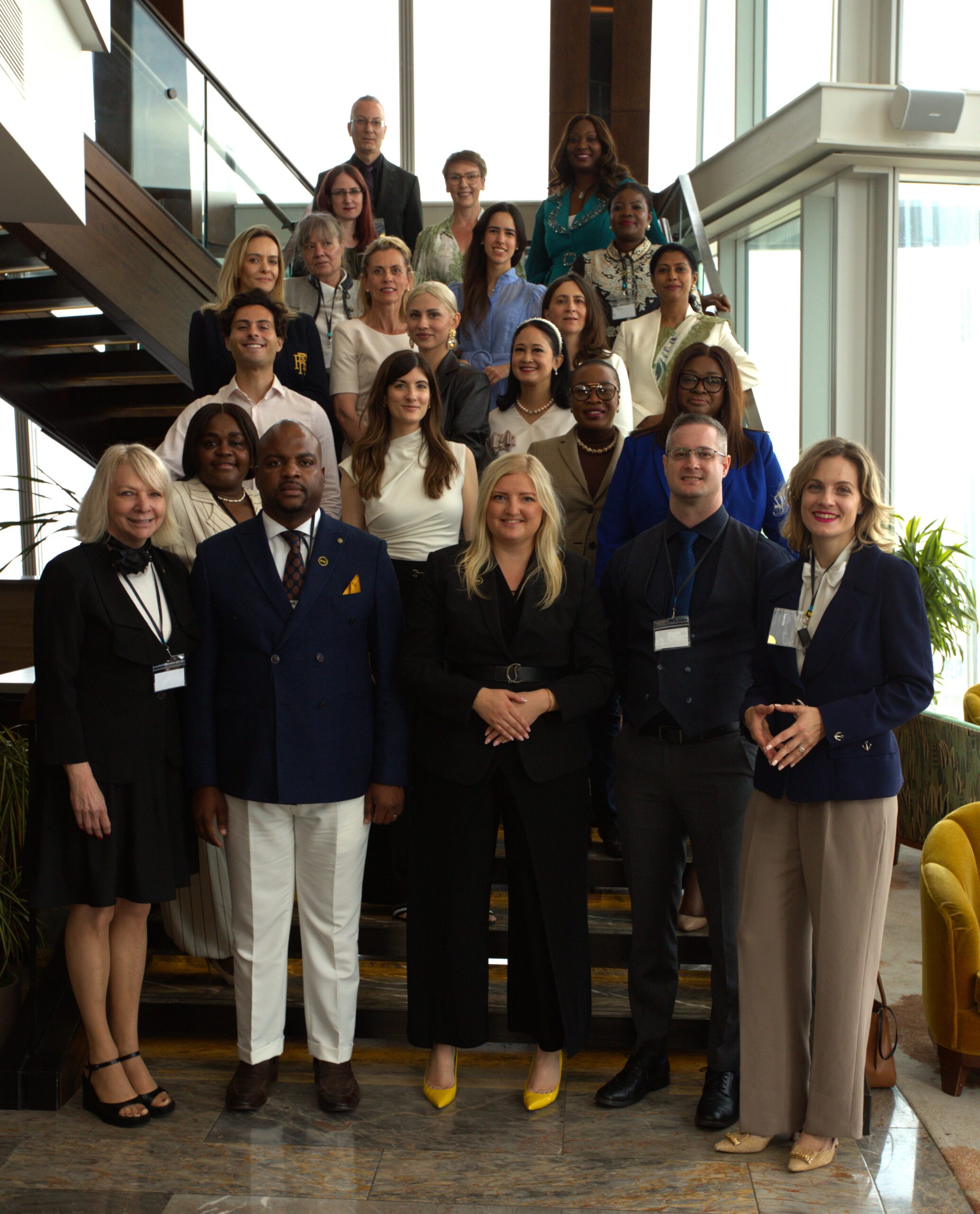 A cohort of Signature Programme graduates gathered on a staircase