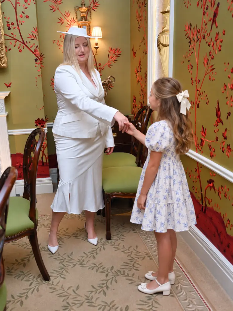 A trainer and a young girl practising a formal handshake