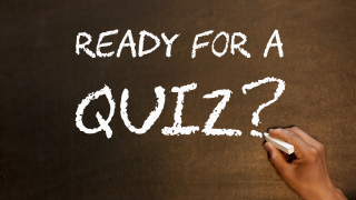 A hand writing, on a chalkboard, the question: Ready for a quiz?